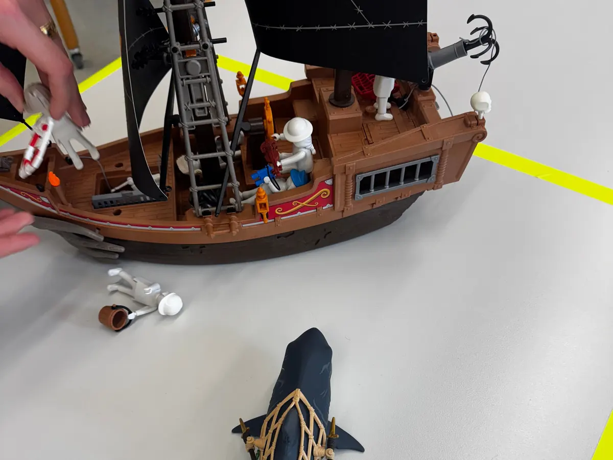 PLAYMOBIL pro Figuren und Schiff auf einem Arbeitstisch während eines Workshops