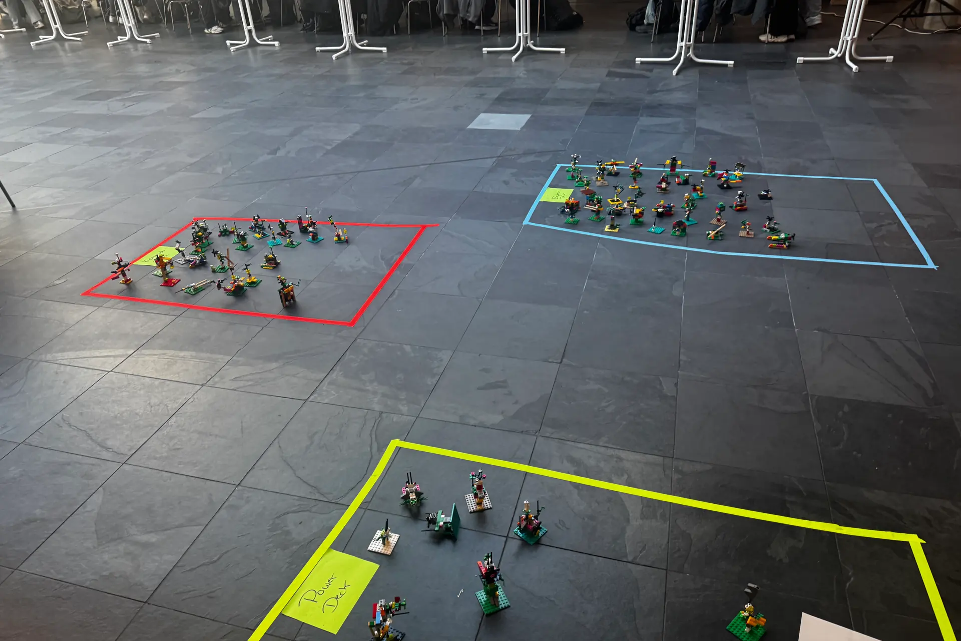 Großgruppen-Workshop mit farbig markierten Zonen und Modellen auf dem Boden